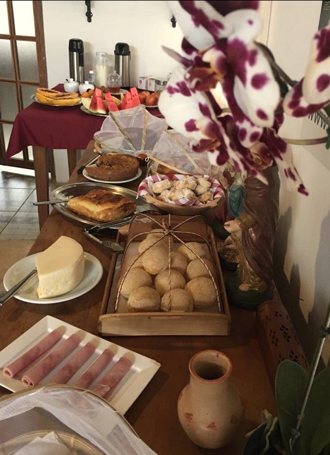 Mesa de café com queijo canastra, pão de queijo, bolos e frutas